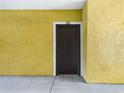 Dark brown front door with yellow stucco wall at 10121 Courtney Palms Blvd # 204, Tampa, FL 33619