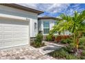 White house with a white garage door, landscaping, and a paved walkway at 8616 Seascape Cv, Parrish, FL 34219