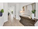 Bright and airy entryway with wood-look floors and stylish console table at 6179 Hidden Branch Dr, Apollo Beach, FL 33572