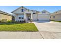 Two-story house with gray siding, stone accents, and a three-car garage at 6179 Hidden Branch Dr, Apollo Beach, FL 33572