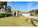 Landscaped lawn with a three-car garage and a charming facade at 8929 Cashella Ct, Trinity, FL 34655