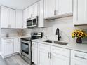 Modern kitchen with white cabinets, stainless steel appliances, and quartz countertops at 2229 Arch Mcdonald Dr, Dover, FL 33527