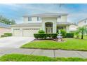 Two-story house with a landscaped lawn, fountain, and attached two-car garage at 4224 Fleewell Ct, Valrico, FL 33596