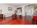 Living room with hardwood floors, light-colored sofa, and a piano at 4224 Fleewell Ct, Valrico, FL 33596