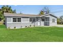 Charming gray home with a well-manicured lawn and front yard landscaping at 541 E Lime St, Tarpon Springs, FL 34689