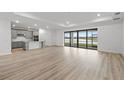 Spacious living room features a large window overlooking a serene lake, filling the space with natural light at 2719 Winding Creek Trl, North Port, FL 34289