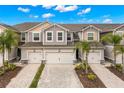 Charming townhouse showcasing a neutral palette, two-car garage, brick-paved drive, and manicured landscaping at 5018 Sunnyside Ln, Bradenton, FL 34211