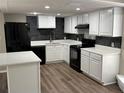 Modern kitchen with white cabinets, black appliances, and quartz countertops at 6969 Oldgate Cir, New Port Richey, FL 34655