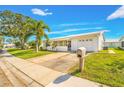 White house with palm trees, a neatly landscaped lawn, and a driveway at 9125 39Th N Ln, Pinellas Park, FL 33782