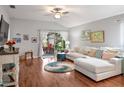 Bright living room featuring a sectional sofa, hardwood floors, and access to a patio at 31932 Stillmeadow Dr, Wesley Chapel, FL 33543