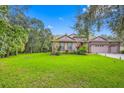 House exterior showcasing a large yard and lush landscaping at 12532 River Birch Dr, Riverview, FL 33569