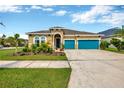 House exterior featuring a teal garage and manicured landscaping at 5502 Limelight Dr, Apollo Beach, FL 33572