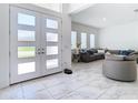 Bright and spacious entryway with double doors and a view into the living room at 8731 Sanders Tree Loop, Wesley Chapel, FL 33545