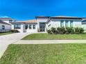 A modern, single-story home with a tiled driveway and landscaped front yard at 8731 Sanders Tree Loop, Wesley Chapel, FL 33545