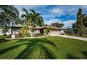 Inviting home featuring a well-maintained lawn, mature trees, and a two-car garage at 2342 Hazelwood Ln, Clearwater, FL 33763