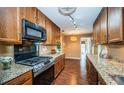 Well-lit kitchen features granite countertops, wooden cabinets, and modern stainless steel appliances at 2342 Hazelwood Ln, Clearwater, FL 33763