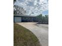 Ranch style home with a light blue exterior, palm trees, and a large driveway at 2716 Miriam S St, Gulfport, FL 33711