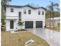 Modern two-story home with three-car garage and landscaped front yard at 7306 Exter Way, Tampa, FL 33615