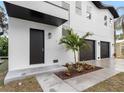 Modern home's front entrance with black door and landscaping at 7306 Exter Way, Tampa, FL 33615