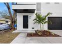 Modern front entrance with black door and landscaping at 7306 Exter Way, Tampa, FL 33615