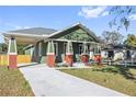 Charming craftsman style home with a green exterior, red brick accents, and a covered porch at 1518 E Knollwood St, Tampa, FL 33610