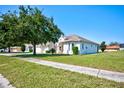 Single-story house with light-colored exterior, attached garage, and well-manicured lawn at 13267 Linzia Ln, Spring Hill, FL 34609