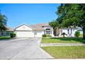 House exterior showcasing a three-car garage and well-maintained landscaping at 13267 Linzia Ln, Spring Hill, FL 34609