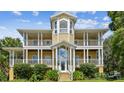 Elegant yellow two-story home with dual porches, a grand entrance, and manicured landscaping at 6231 Bayshore Blvd, Tampa, FL 33611