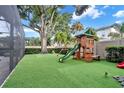 Backyard with artificial turf, playset, and large tree at 4114 W Zelar St, Tampa, FL 33629
