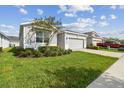 One-story home with gray siding and two-car garage at 13204 Waterleaf Garden Cir, Riverview, FL 33579