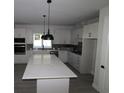 Modern kitchen with white cabinets, quartz countertops, and island at 679 Allora Ave, Nokomis, FL 34275