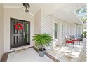 Front entrance with a black door, red wreath, and potted plant at 1300 Cedar Ct, Tarpon Springs, FL 34689