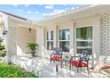 Front porch with brick columns, red chairs, and a small table at 1300 Cedar Ct, Tarpon Springs, FL 34689