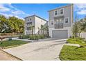 Two-story townhouses with gray siding, attached garages, and a shared courtyard at 208 W Frances Ave # 3, Tampa, FL 33602