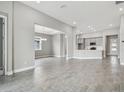 Spacious living room with an open layout and gray tile floors at 2424 Wise River Ln, Zephyrhills, FL 33544