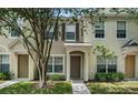 Front view of a tan townhome with green lawn at 4517 Kennewick Pl, Riverview, FL 33578