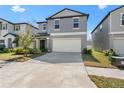 Beautiful gray two-story home with a large driveway leading to an attached two-car garage at 9917 Spanish Lime Ct, Riverview, FL 33578