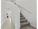 Modern staircase with gray carpeting and white railings at 9917 Spanish Lime Ct, Riverview, FL 33578