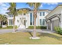 Magnificent two-story home with an attached three-car garage, lush landscaping, and a circular paver driveway at 105 Cordova Ne Blvd, St Petersburg, FL 33704