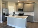 Modern kitchen featuring gray cabinets, quartz countertops, and stainless steel appliances at 5321 Crestline Ter, Port Charlotte, FL 33981