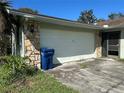 Attached garage of a home with stone accents and a blue recycling bin at 5143 Vassar Ln, Sarasota, FL 34243