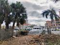 Disturbed lot with debris near boats and waterfront at 113 Boca Ciega Dr, Madeira Beach, FL 33708