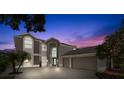 Two-story house with a three-car garage at dusk at 4915 Augusta Ave, Oldsmar, FL 34677