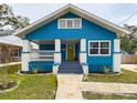 Charming blue home featuring a cozy front porch and a colorful green door at 5205 N 9Th St, Tampa, FL 33603