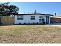 A well-maintained single-story home with white exterior, dark trim, and a green lawn in front at 9322 88Th Way, Seminole, FL 33777