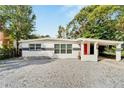 Newly renovated ranch home with red front door and gravel driveway at 4814 N Highland Ave, Tampa, FL 33603