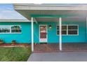 Inviting front porch with terracotta tile flooring and a pink door at 2315 Nash St, Clearwater, FL 33765