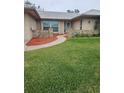 House exterior featuring a landscaped lawn, walkway, and stone accents at 11933 72Nd Ave, Seminole, FL 33772