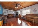 Bright living room featuring hardwood floors, wood ceiling beams, and a vintage piano at 809 41St N Ave, St Petersburg, FL 33703