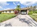 Inviting single-story home featuring a carport, lush landscaping, and a well-kept lawn at 2104 Hembury Pl # 33, Sun City Center, FL 33573